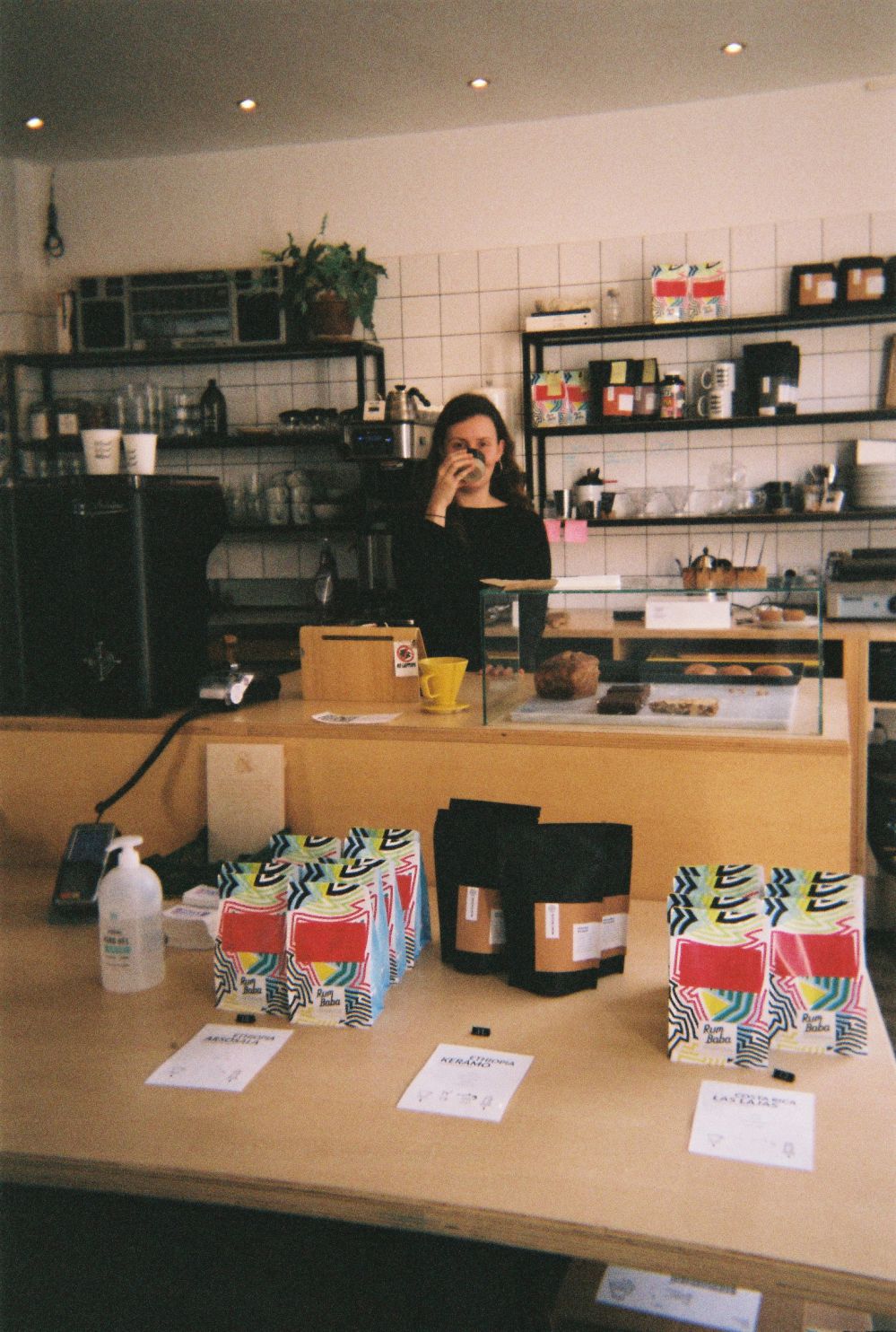 vrouw achter een balie drinkt kop koffie