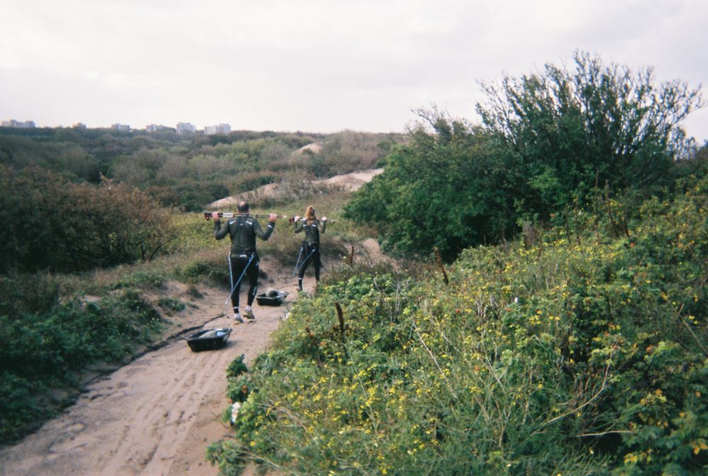 Foto van mensen in de natuur die aan het sporten zijn met een sleetje